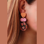 Photo of earring with irregular orange shape, irregular pink shape, and multicoloured disc-shape