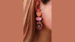 Photo of earring with irregular orange shape, irregular pink shape, and multicoloured disc-shape