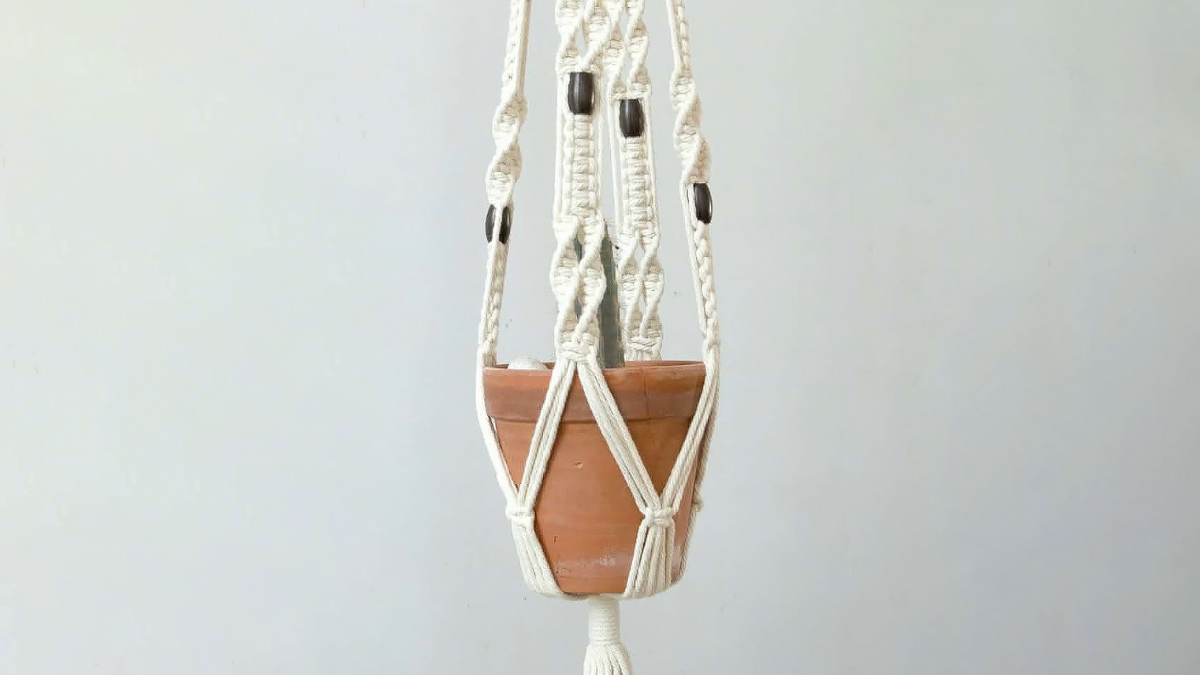 Small terracotta pot hanging from rope macrame