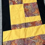 Photo of table runner featuring motif of Aboriginal artwork