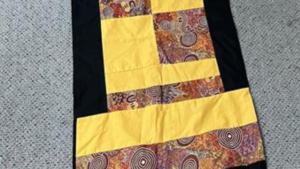 Photo of table runner featuring motif of Aboriginal artwork